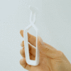Hand holding white plastic bag clip.